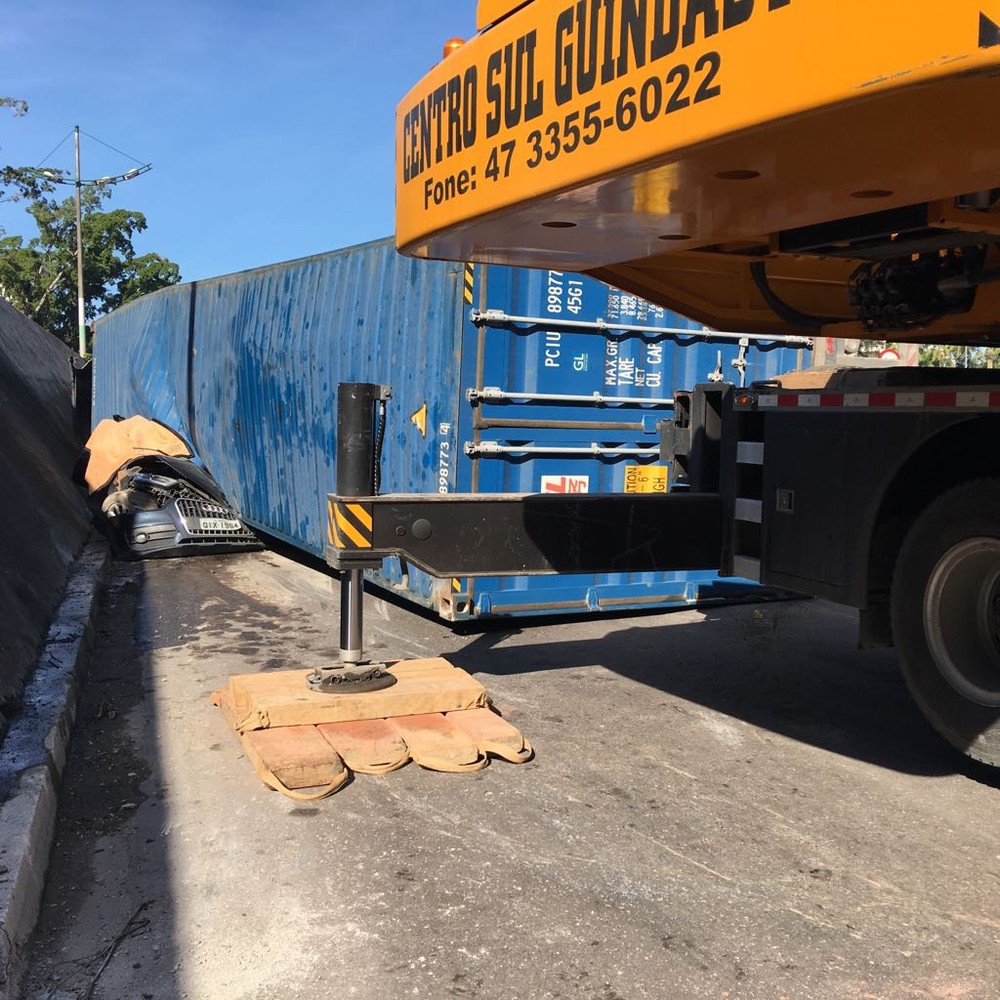 Contêiner cai de carreta, atinge carro e mata grávida