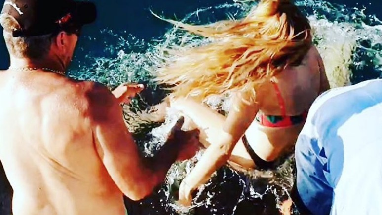   Mulher tenta alimentar tubarão e acaba puxada e abocanhada pelo animal