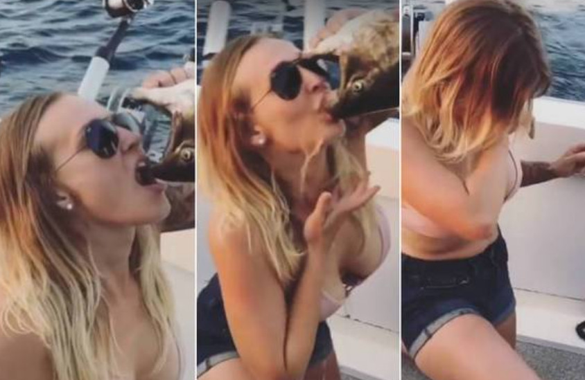 Mulher bebe cerveja direto da boca de peixe morto
