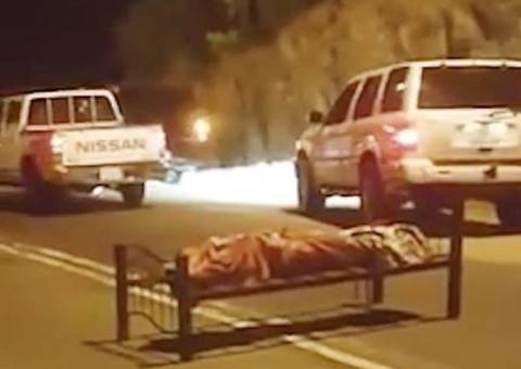 Em cima de cama, corpo é abandonado no meio de rodovia movimentada