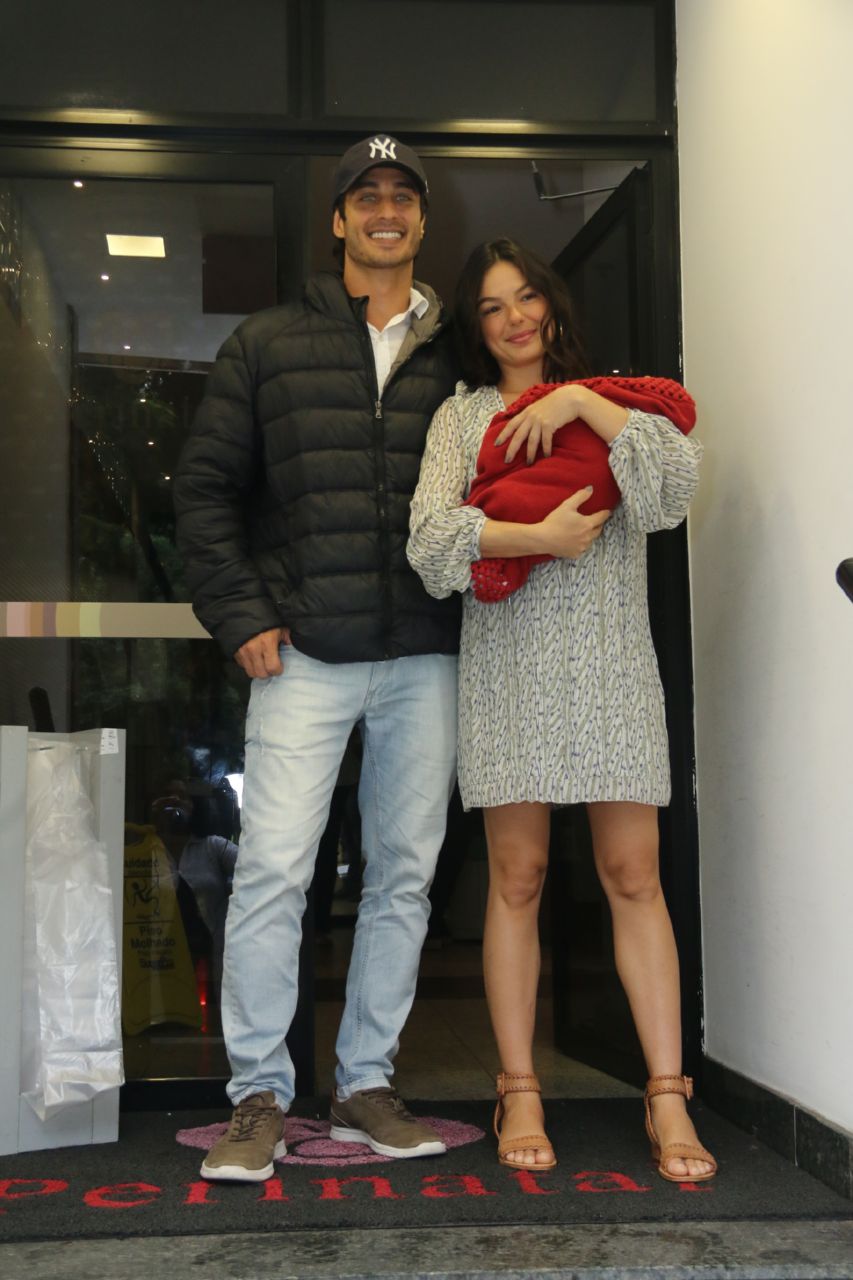 Sorridente, Isis Valverde deixa maternidade com filho no colo