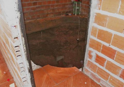 Pai, mãe e três filhos caem em cratera de 5 metros após quarto desabar