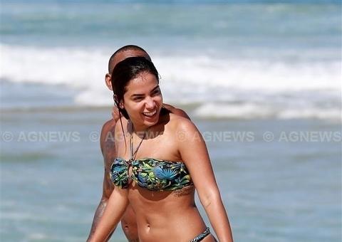 De barriga para cima, Anitta é flagrada fazendo topless em praia do Rio de Janeiro