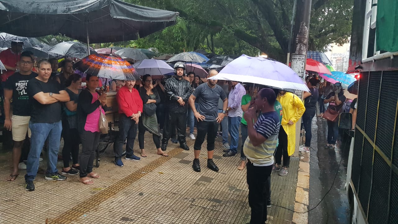 Oficial de Justiça tenta notificar professores sob chuva para impedir greve em Manaus