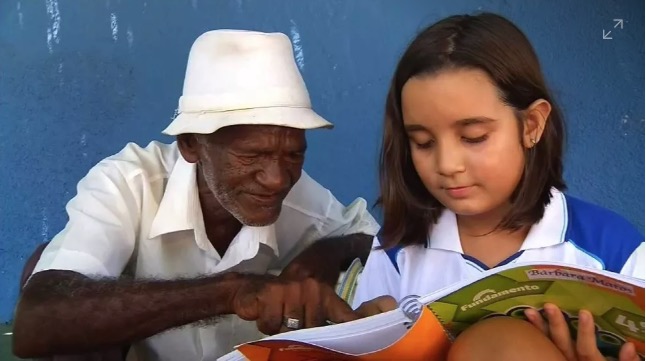 Criança ajuda a 'alfabetizar' vendedor de picolé que trabalha há 40 anos em escola