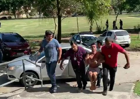 Suspeito de cometer mais de 100 roubos a ônibus é carregado com mãos e pés amarrados para delegacia