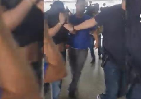 Com rosto coberto, Alejandro Valeiko chega à delegacia onde ficará preso