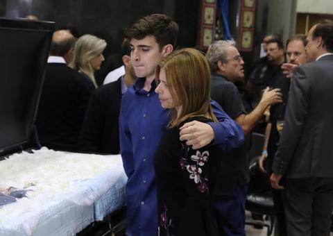 Abraçado à mãe, filho de Gugu Liberato deixa lembrança no caixão do pai