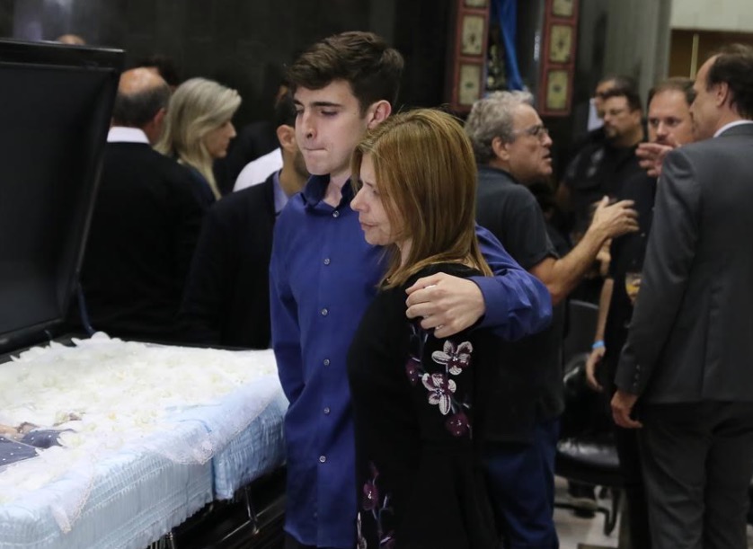 Abraçado à mãe, filho de Gugu Liberato deixa lembrança no caixão do pai