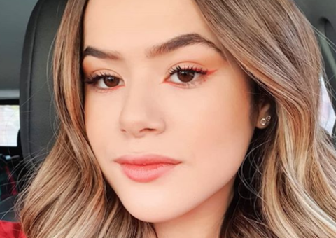 Maisa se esconde atrás do pai para não ser fotografada em aeroporto 