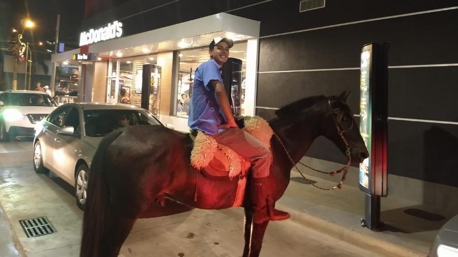 Jovem rouba a cena ao aguardar em fila de drive thru com cavalo