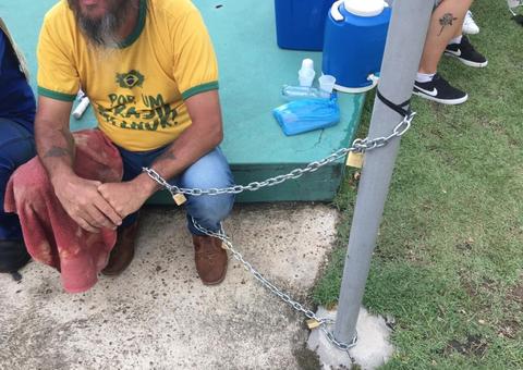 Acorrentado a poste em frente a Aleam, caminhoneiro pede redução de ICMS sobre combustíveis