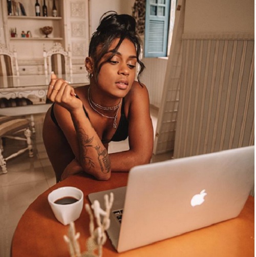 Com bumbum empinado, MC Rebecca posa de lingerie preta ao trabalhar em casa