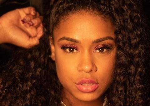 Com bumbum empinado, MC Rebecca posa de lingerie preta ao trabalhar em casa