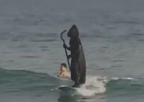 'Morte' aterroriza banhistas ao ser vista surfando em praia