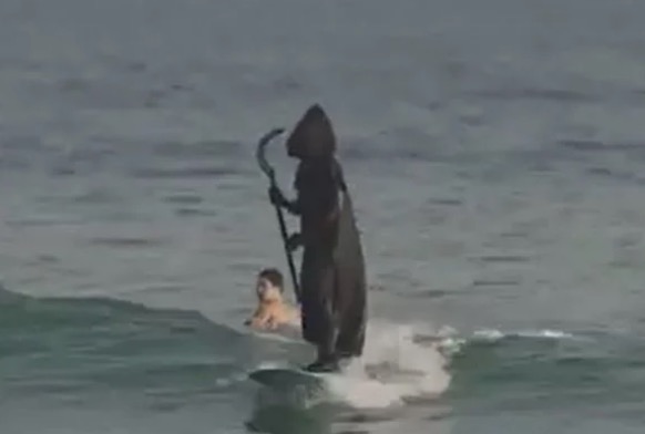 'Morte' aterroriza banhistas ao ser vista surfando em praia
