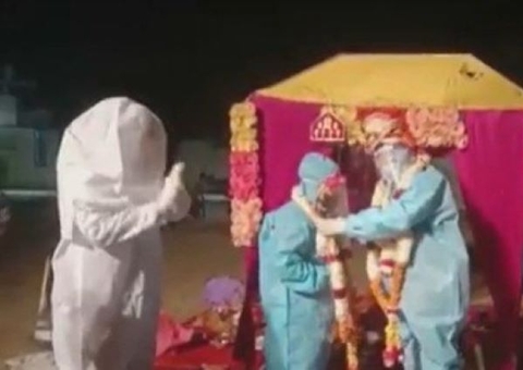 Noiva com covid-19 usa roupa de proteção durante cerimônia de casamento