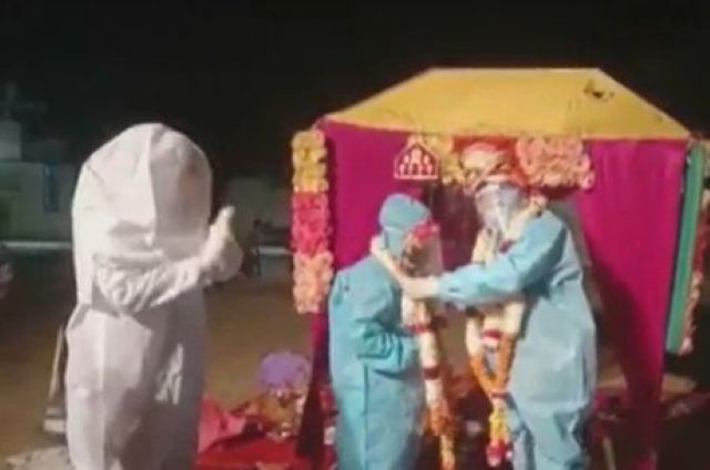 Noiva com covid-19 usa roupa de proteção durante cerimônia de casamento