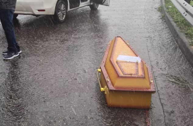 Caixão com corpo dentro é encontrado pela polícia no meio da pista 