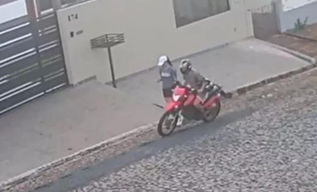 Homem cai de moto ao esticar braço para assediar pedestre; vídeo