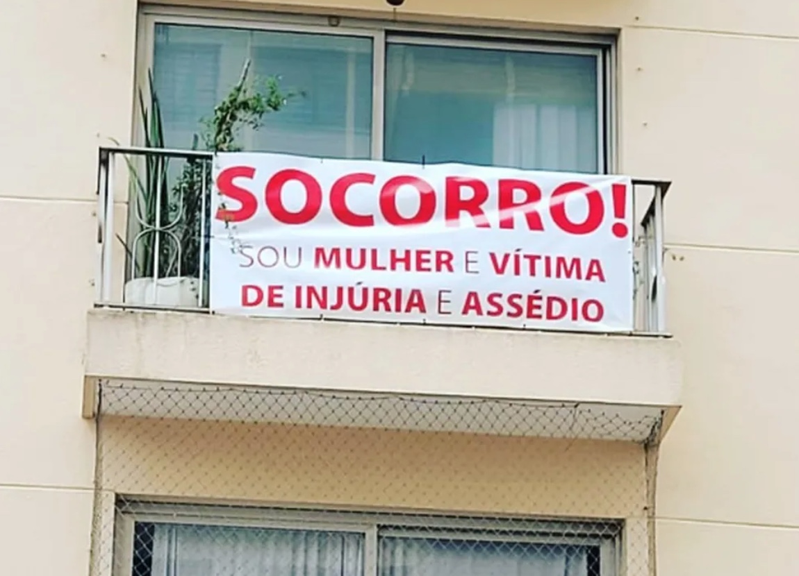 Mulher pede socorro com faixa na varanda para denunciar vizinho por assédio