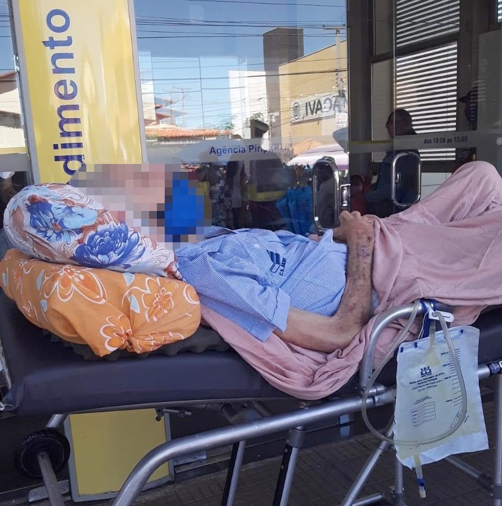 Idoso é levado em maca para agência bancária para poder receber aposentaria no INSS
