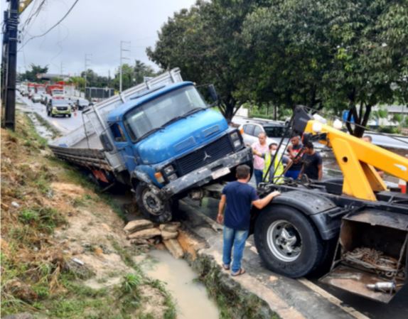 Caminhão de cerveja tomba em avenida alagada e provoca trânsito em Manaus