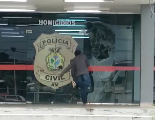 Vídeo mostra mulher aos berros apedrejando porta de delegacia em Manaus