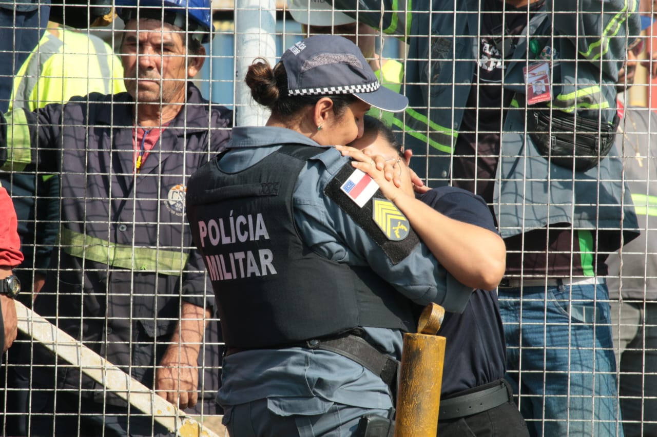 Esposa de motorista esmagado por carreta entra em desespero e é consolada por policial