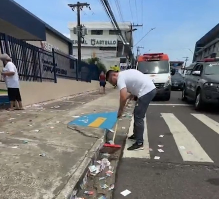 Com vassoura nas mãos, candidato varre santinhos espalhados por rua de Manaus