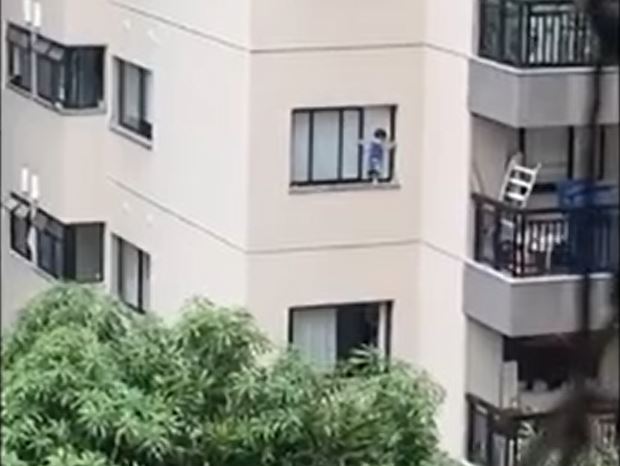 Criança fica pendurada em janela de apartamento e vizinhos se desesperam; Veja vídeo
