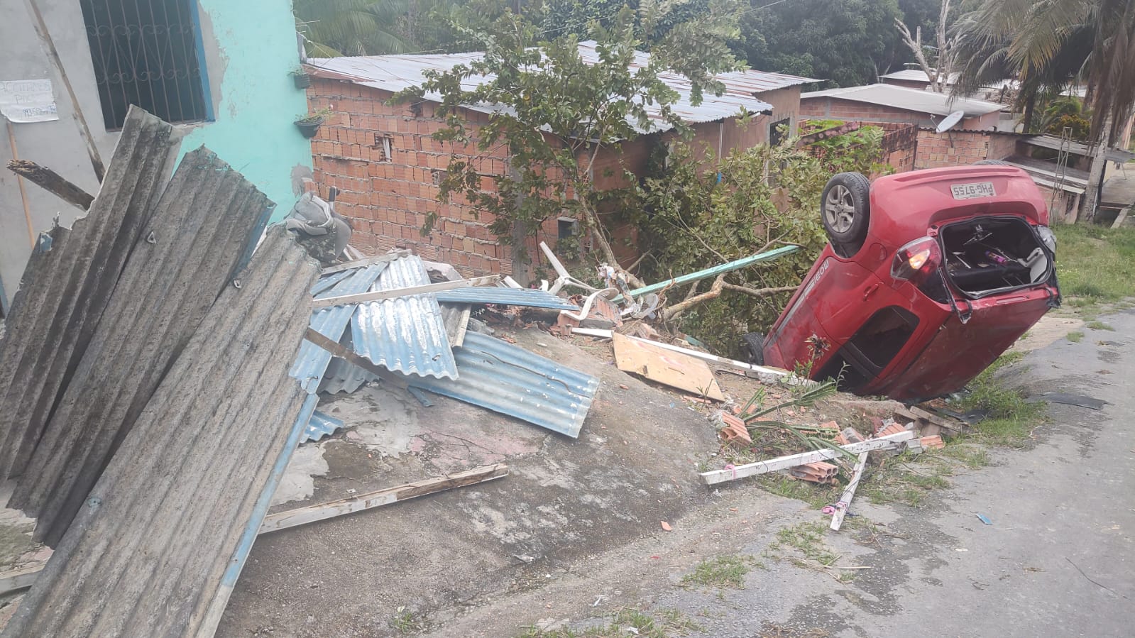Carro perde direção em ladeira, destrói parte de casa e cai em barranco em Manaus