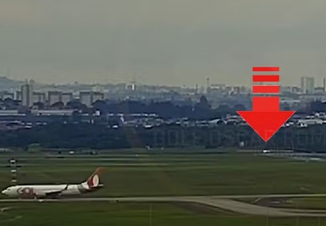 Crianças são vistas na pista do Aeroporto de Guarulhos durante pouso de aeronaves