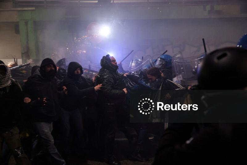 Manifestantes lançam fogos de artifício contra a polícia na cidade olímpica de Milão