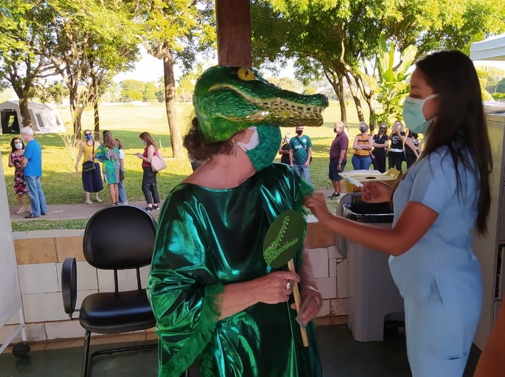 Fantasiada de jacaré, idosa de 69 anos é vacinada contra Covid-19 no DF