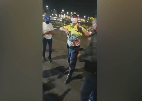 Policial puxa arma ao ser cercado por manifestantes em invasão à Esplanada dos Ministérios