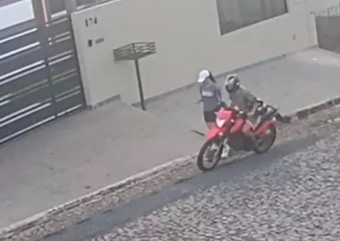 Homem cai de moto ao esticar braço para assediar pedestre; vídeo
