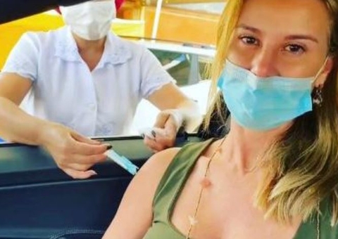 Com máscara na boca e nariz de fora, mulher de Flávio Bolsonaro toma vacina