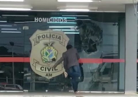 Vídeo mostra mulher aos berros apedrejando porta de delegacia em Manaus