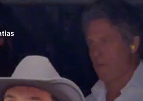 Vídeo: Hugh Grant é flagrado com protetor auricular no meio do show de Taylor Swift