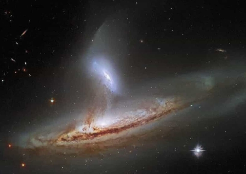 Hubble fotografou uma galáxia sugando material cósmico