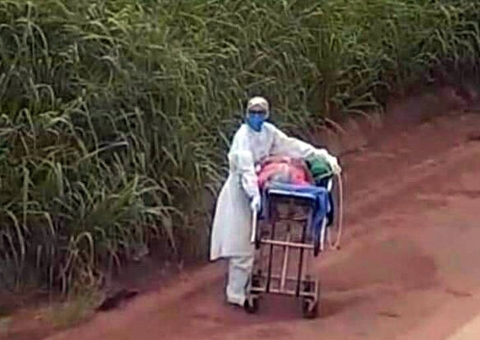 Enfermeira e motorista empurram paciente com Covid em maca no meio de BR