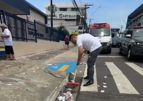 Com vassoura nas mãos, candidato varre santinhos espalhados por rua de Manaus