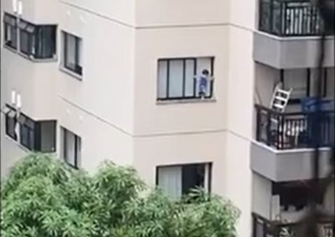 Criança fica pendurada em janela de apartamento e vizinhos se desesperam; Veja vídeo