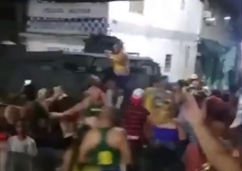 Vídeo: Folião sobe em 'caveirão' da PM durante bloco de Carnaval clandestino