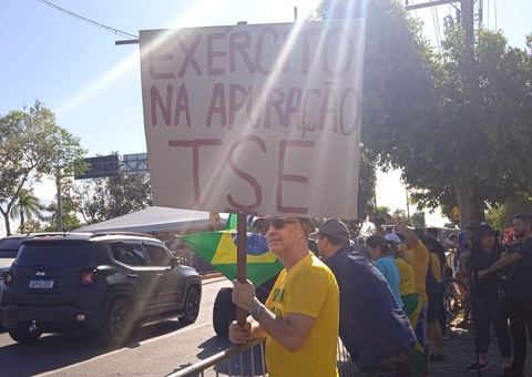 Apoiadores de Bolsonaro levam faixas em apoio ao presidente durante motociata