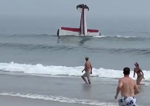 Avião faz pouso forçado e capota próximo a banhistas no mar