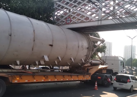 Caminhões ficam presos debaixo de passarela na Ponta Negra