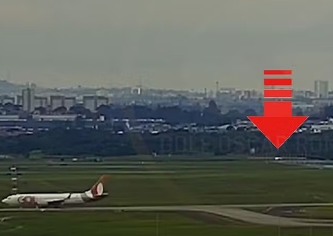 Crianças são vistas na pista do Aeroporto de Guarulhos durante pouso de aeronaves