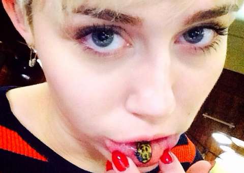 Miley faz tatuagem na boca e publica foto enrolando cigarro de maconha